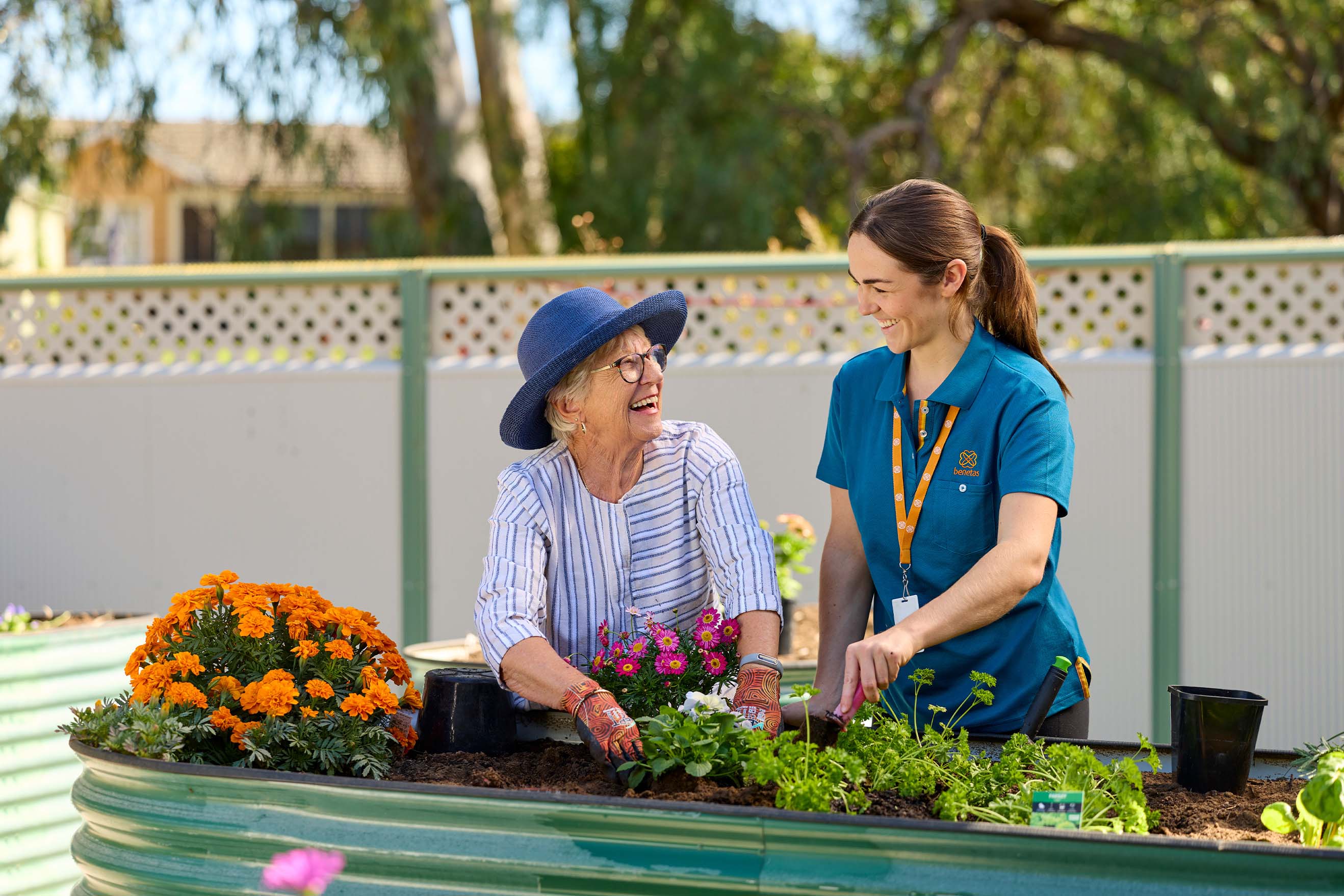 Resident and Benetas team member gardening together in a raised garden bed at Benetas Kangaroo Flat