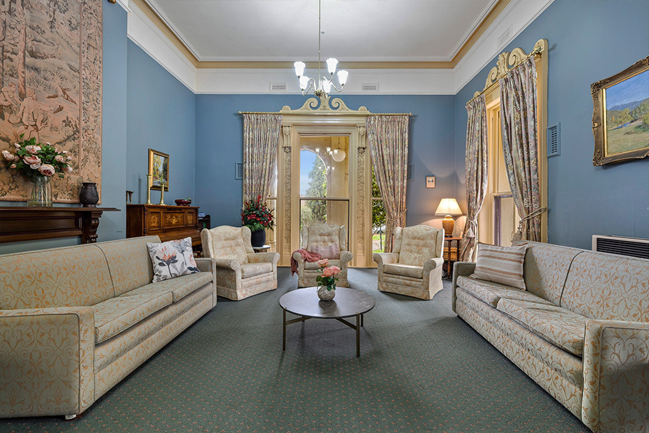 A sitting room with blue walls and a fireplace, creating a serene ambiance.