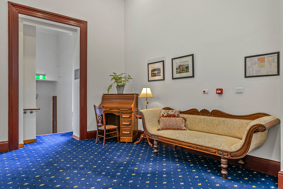 A room with a comfortable couch and a functional desk, perfect for relaxation and work.