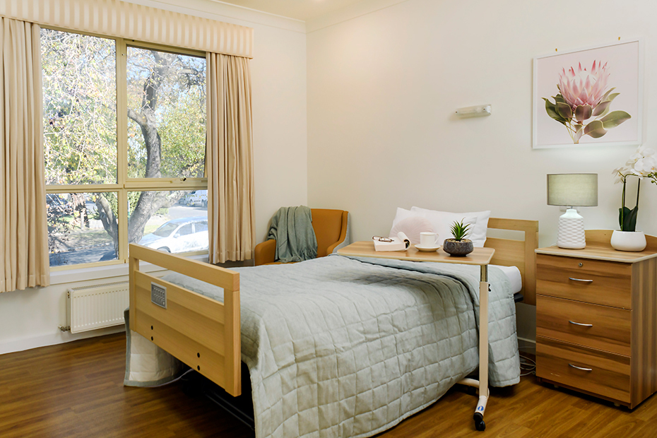 A cozy room with a bed, desk, and window.