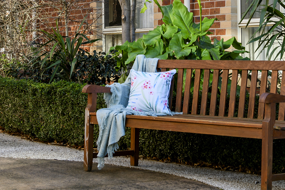 A simple wooden bench in a serene setting, providing a comfortable spot to rest and enjoy nature's beauty.