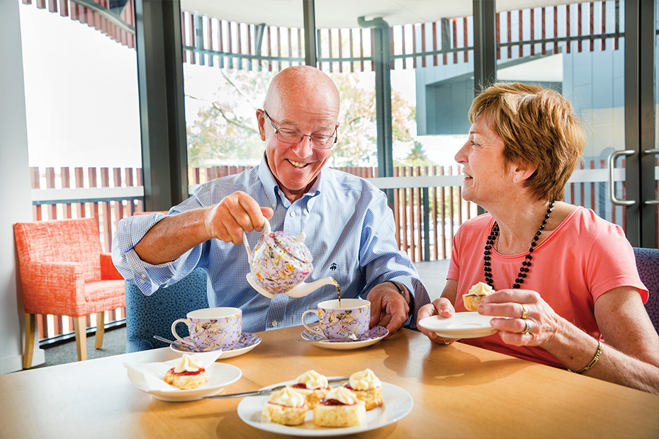 An older couple savoring tea and biscuits together, cherishing their time and creating beautiful memories.