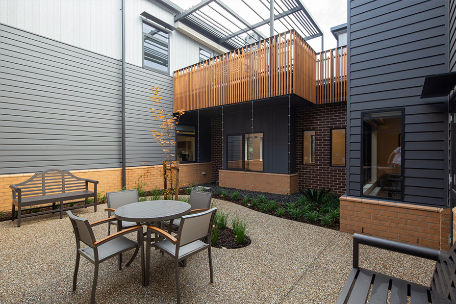 A patio with a table and chairs in front of a building.