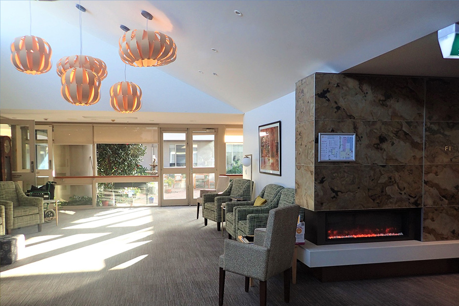 A warm and inviting lobby with a crackling fireplace and comfortable chairs, perfect for relaxation and warmth.