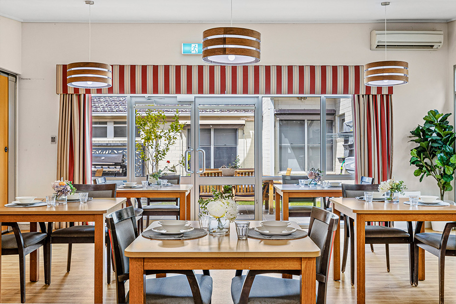 Gladswood Lodge dining room interior with neatly arranged tables and chairs, creating a welcoming and comfortable dining space.