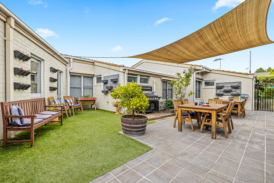 A covered patio with a table and chairs, providing a comfortable outdoor space for relaxation and dining.