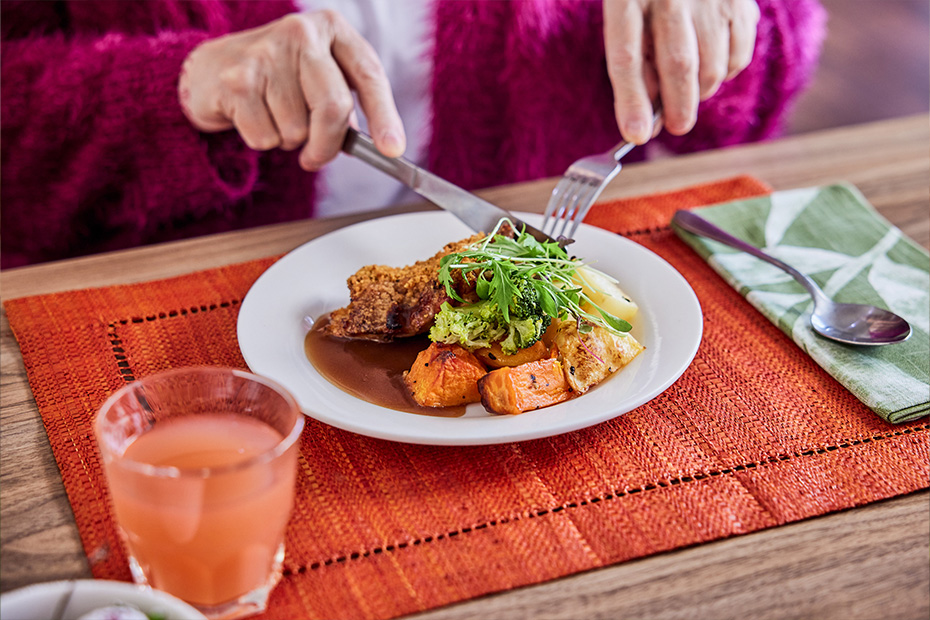 A woman enjoying a meal, savoring each bite with delight.