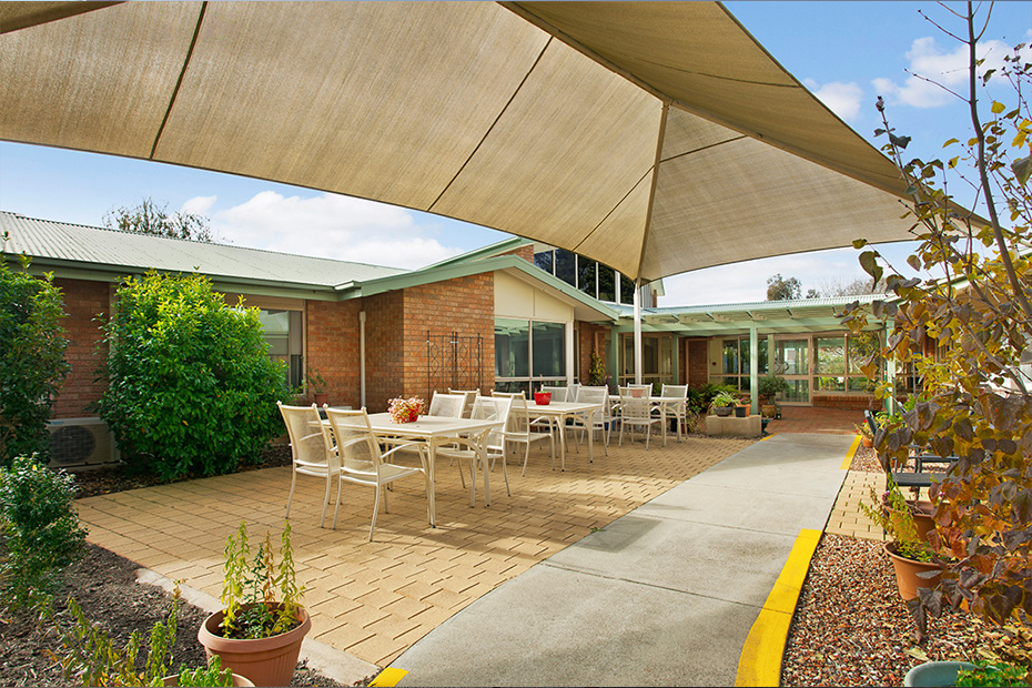 A shaded patio with tables and chairs, providing a comfortable outdoor seating area.