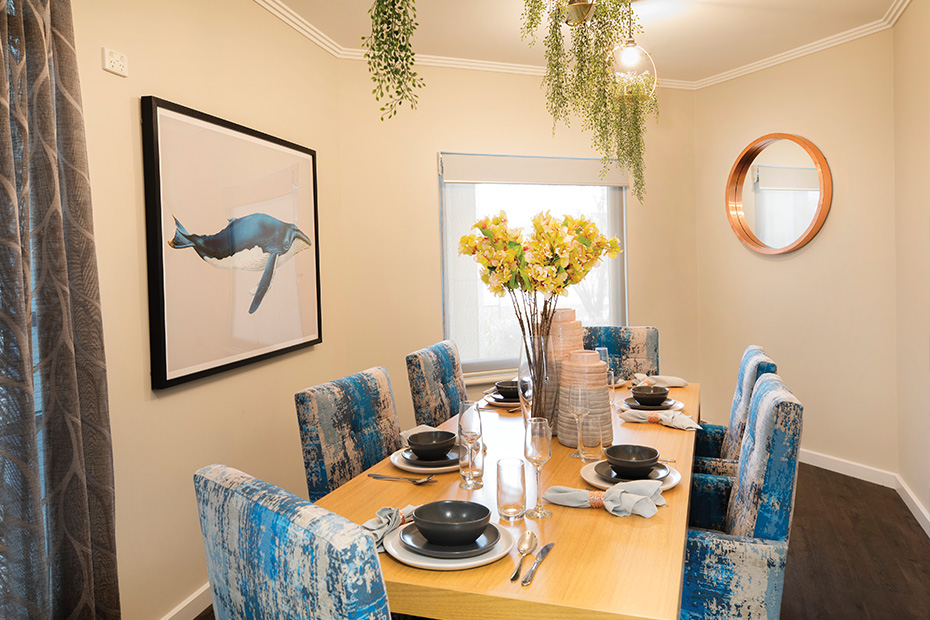 A dining room table with blue chairs, creating a stylish and inviting atmosphere for meals and gatherings.