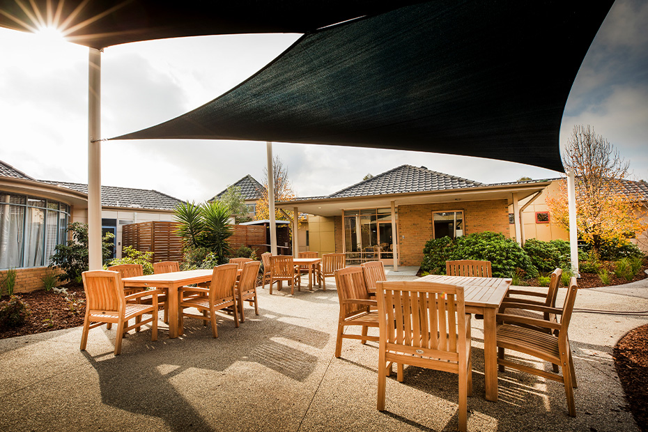 A shaded patio with tables and chairs, providing a comfortable outdoor seating area.