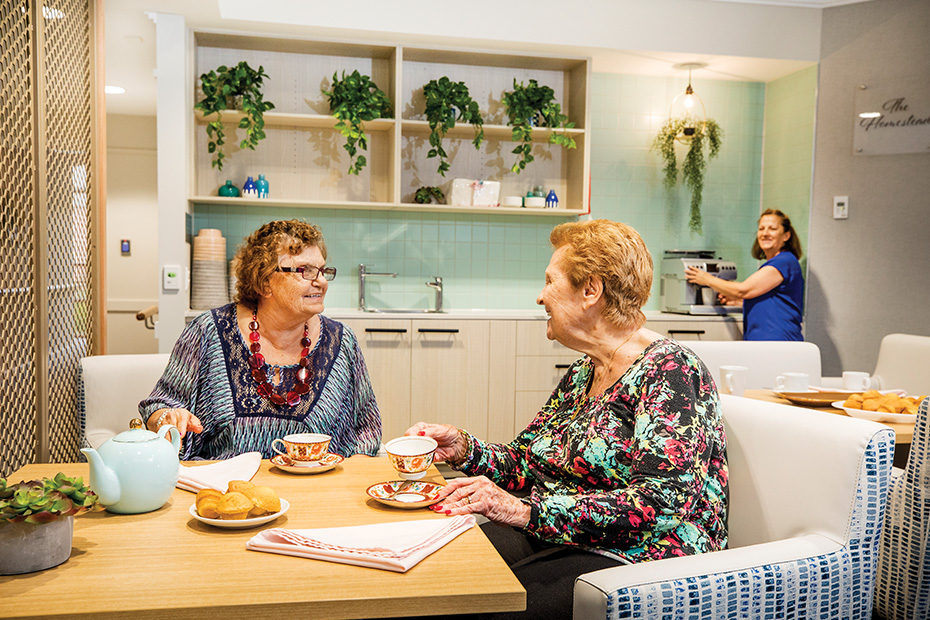 Two women enjoying a meal together in the dining room, engaged in conversation and savoring the moment.
