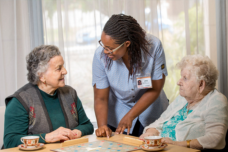 A young woman enjoying a game with two older women, creating a joyful and engaging atmosphere.