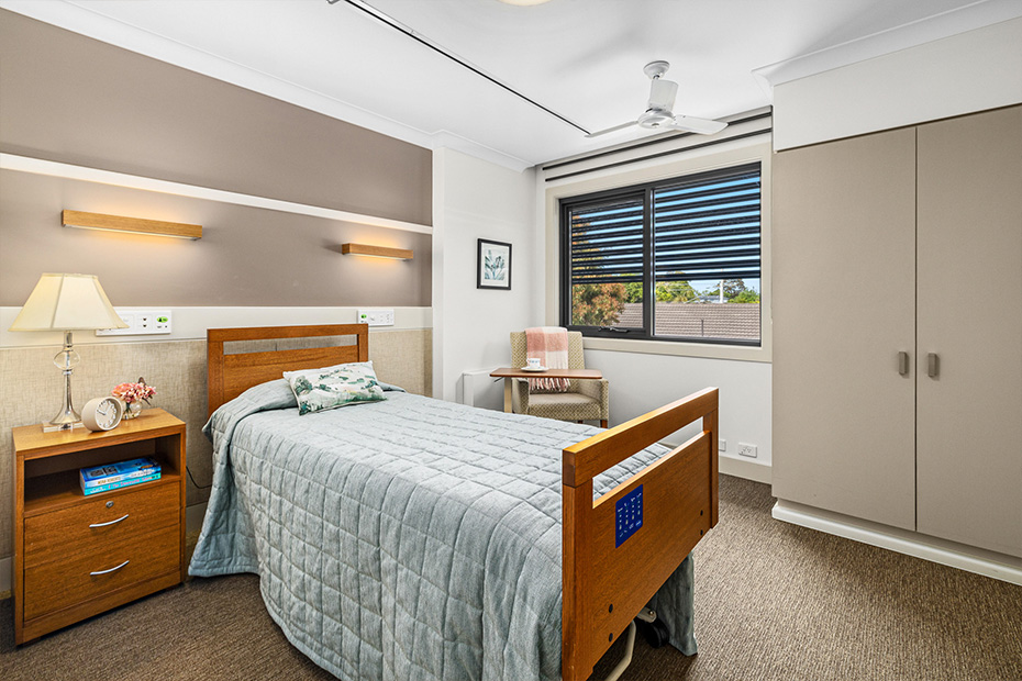 A modern room with a bed, desk, and window.
