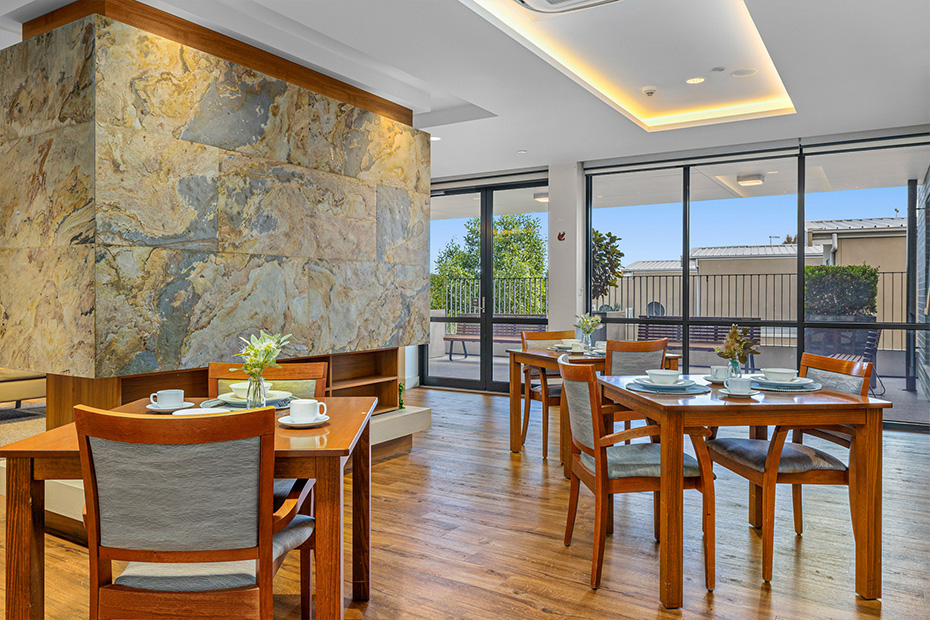 A cozy dining room with a stone fireplace and warm wooden floors, creating a rustic and inviting ambiance.
