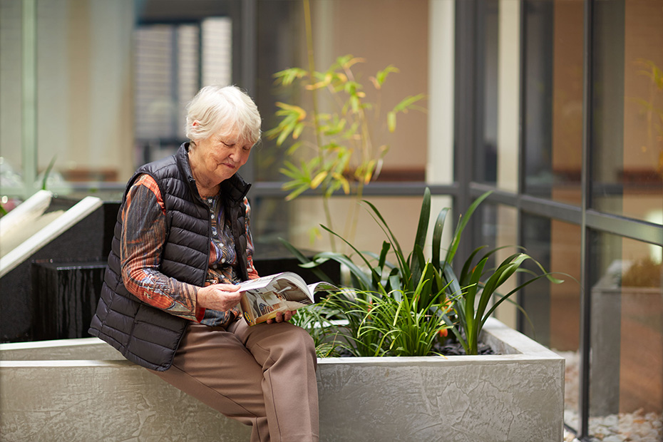 A woman engrossed in a book while sitting on a bench.