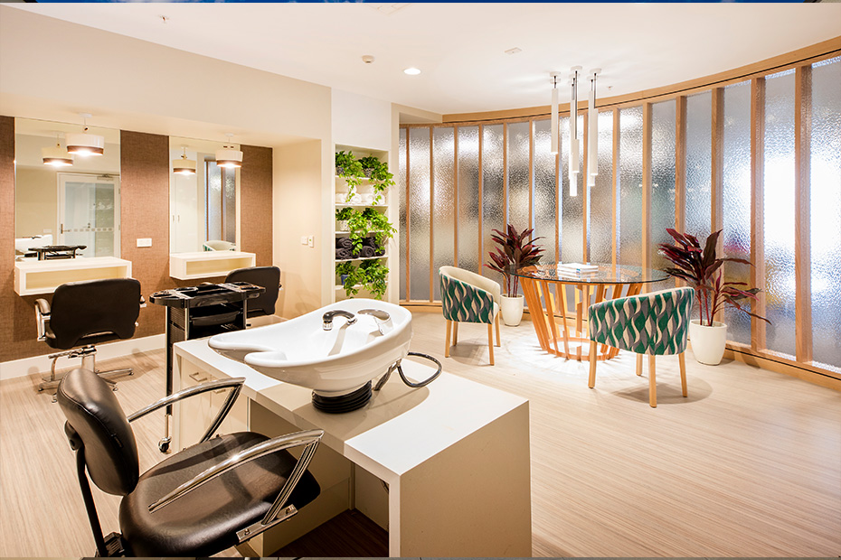 A salon with modern chairs and a sink for hair washing.
