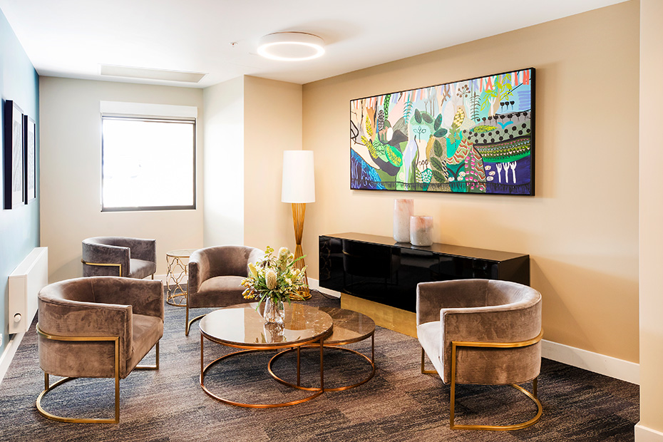 A cozy living room with a beautiful painting hanging on the wall.