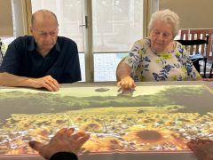 Elderly couple enjoying an interactive game, benefiting from Tovertafel technology at Benetas Clarinda on the Park.
