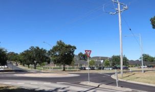 A bustling street corner with a traffic light and a road, showcasing the progress of our seniors living health and ageing precinct in the Macedon Ranges.