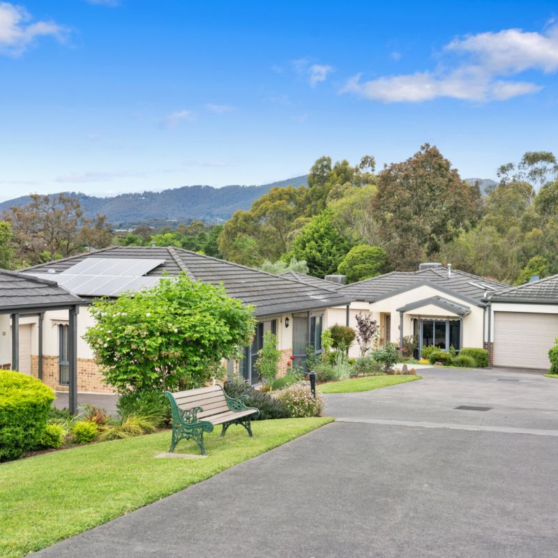 Retirement community with single level homes, manicured lawns, and mountain backdrop